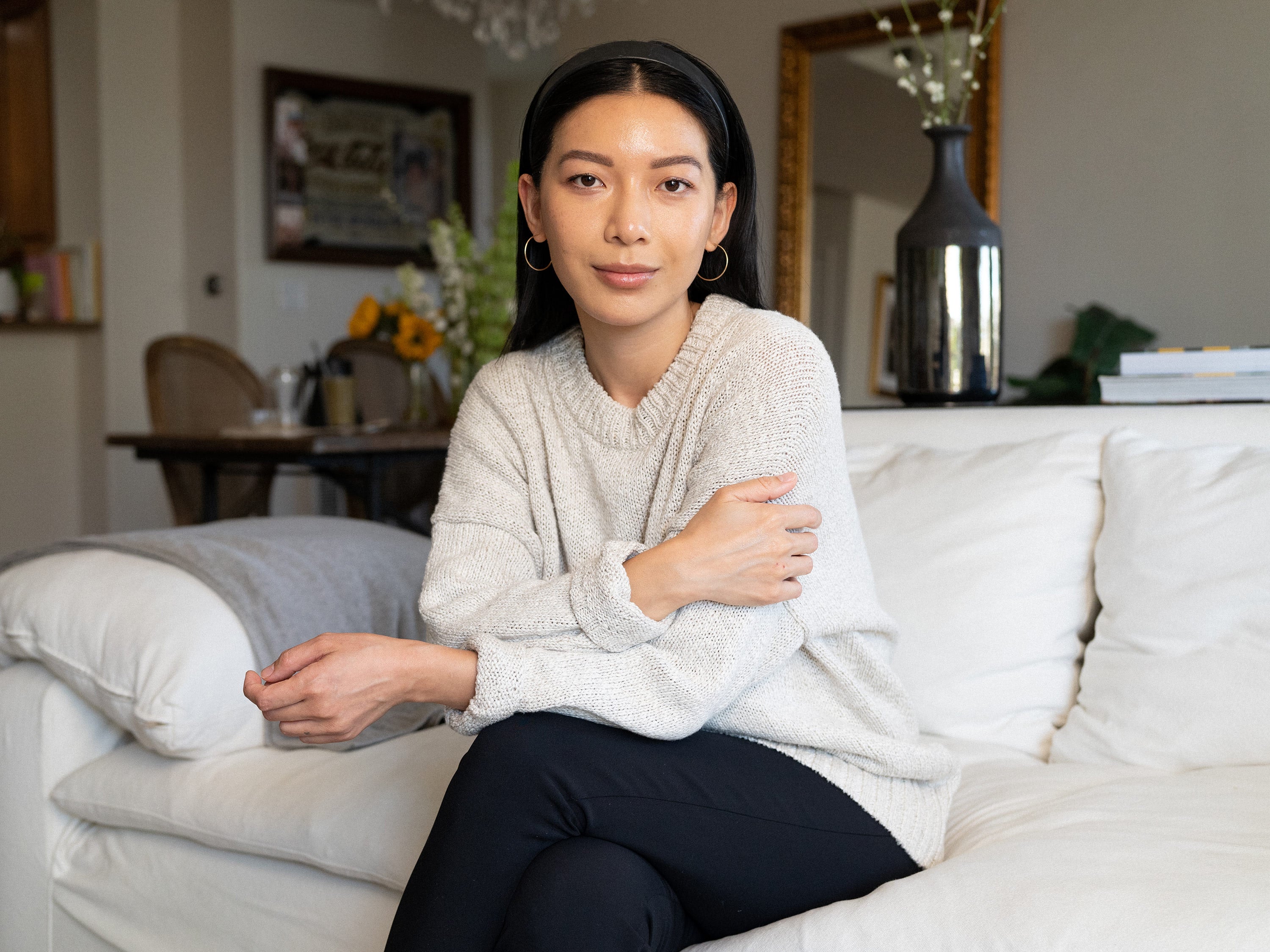 Stephanie Liu Hjelmeseth sitting on a couch, making eye contact with the camera.